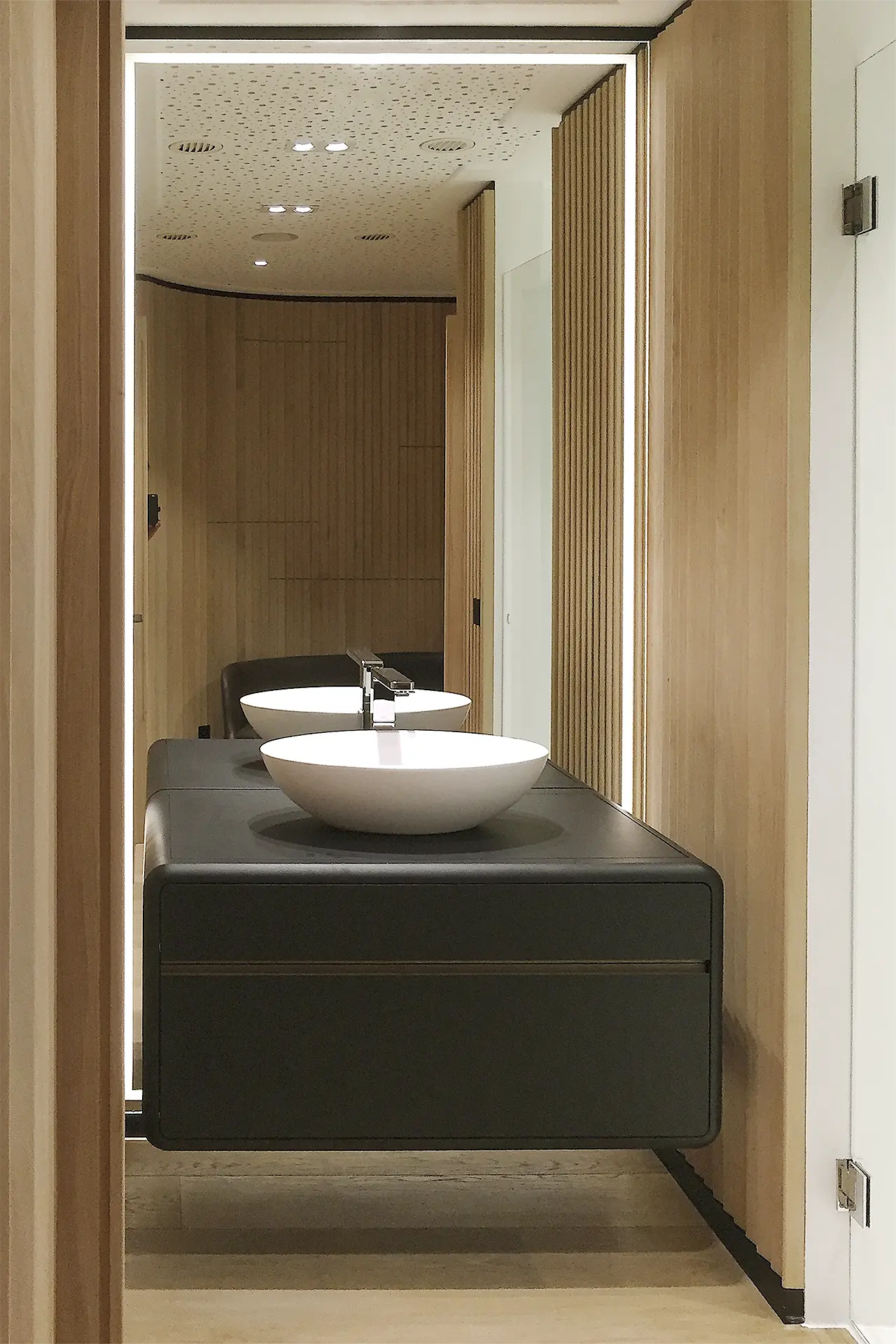 Ulrich Weinkath – Office – Handwaschbecken Weißes Handwaschbecken mit schwarzen Schrankunterbau und großen Spiegel.